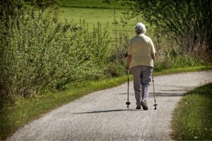 Eine ältere Dame betreibt Nordic Walking